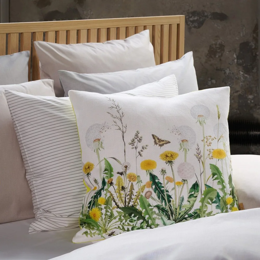 A bed with pillows and a pillow with flowers on it