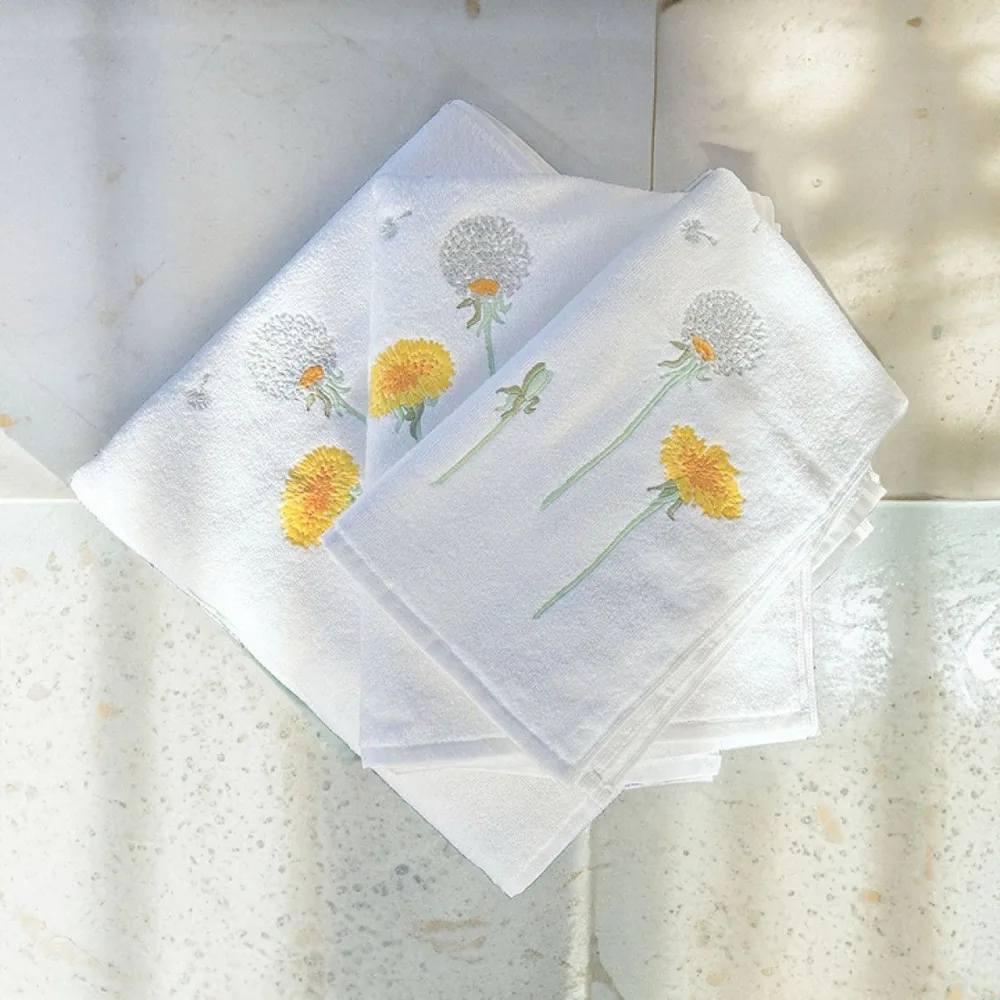 A stack of white towels with yellow flowers on them