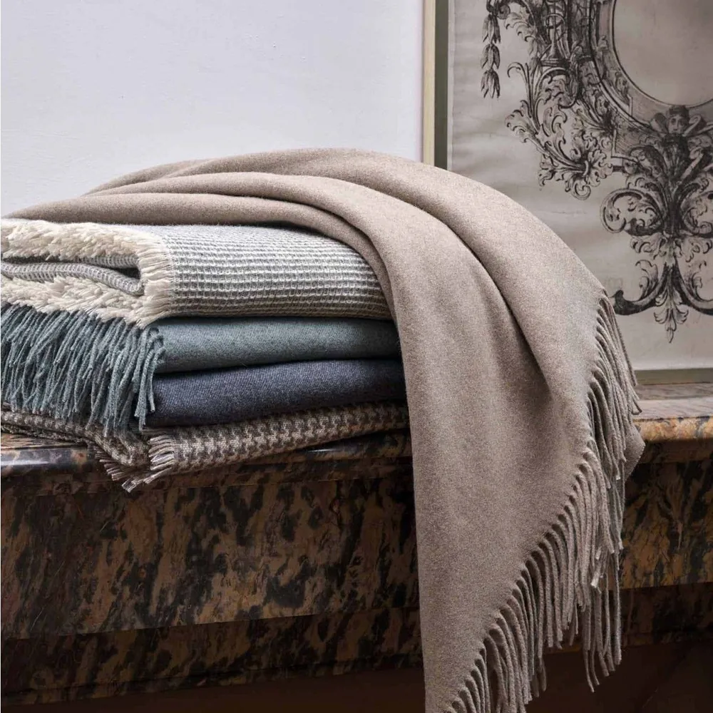A stack of blankets sitting on top of each other on a bench.