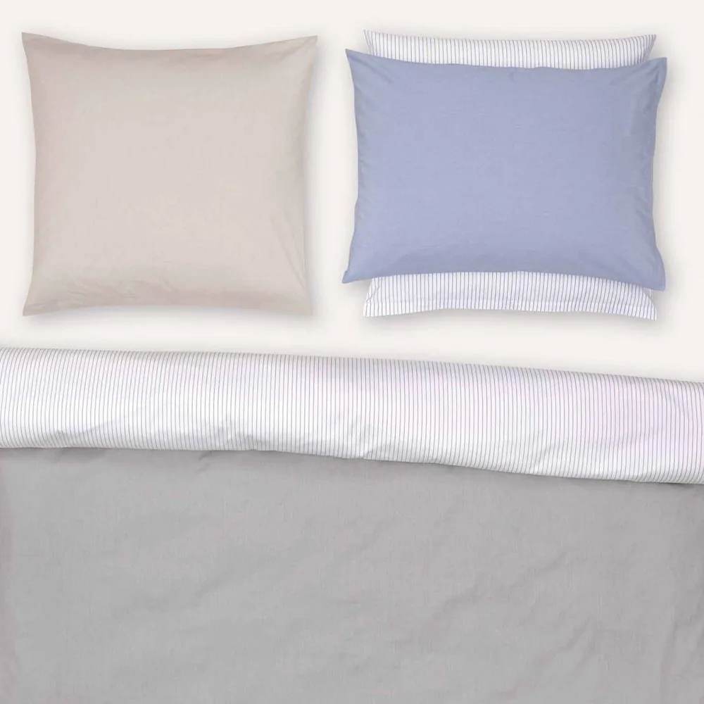 A bed with a comforter and two pillows on it
