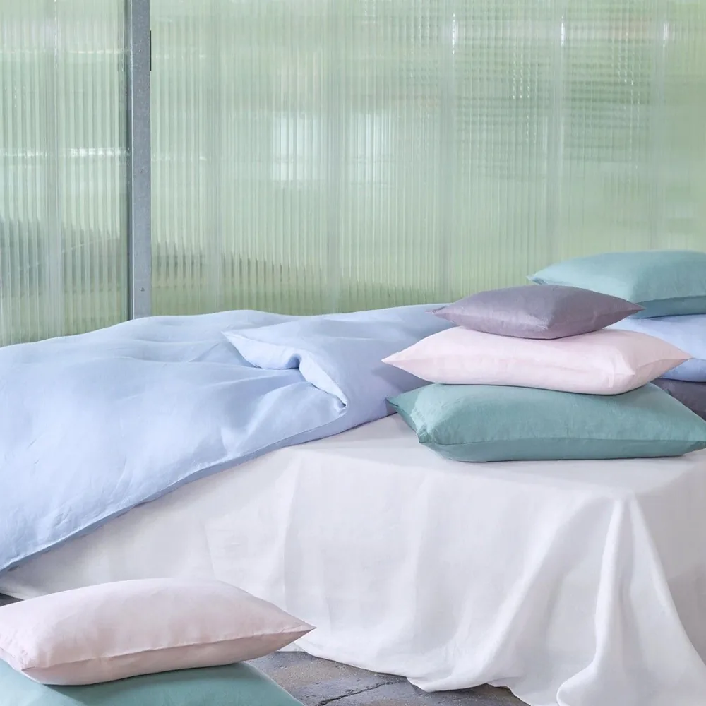 Un lit avec une pile de coussins dessus.